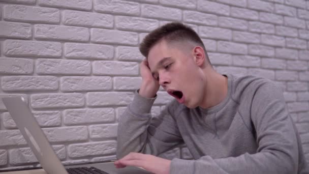 Уставший зевающий человек использует ноутбук, офисный работник, дистанционное дистанционное дистанционное обучение — стоковое видео