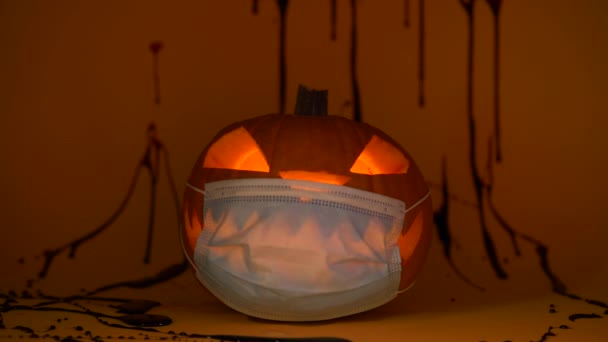 Halloween pompoen in beschermende medische masker, coronavirus kostuum, nep bloed — Stockvideo