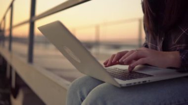 Serbest çalışan kadın laptopunu açık hava mesafesi kullanarak çalışıyor.