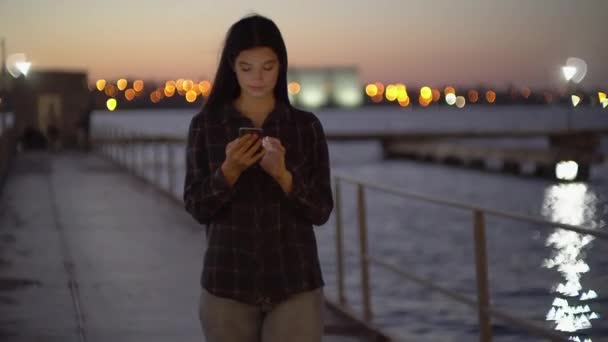 Attraktiv kvinna går på piren och använder laptop på natten, bloggare influencer — Stockvideo