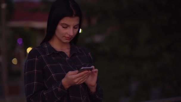Kvinna med hjälp av smartphone promenader på gatan, svepande skärm, sms, bloggare — Stockvideo