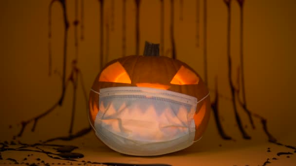 Halloween snidade pumpa Jack lykta glöder i coronavirus skyddande mask — Stockvideo