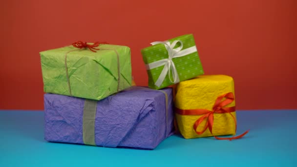 I regali su sfondo di colore, le mani hanno preso la scatola di regali, il concetto di celebrazione di vacanza — Video Stock