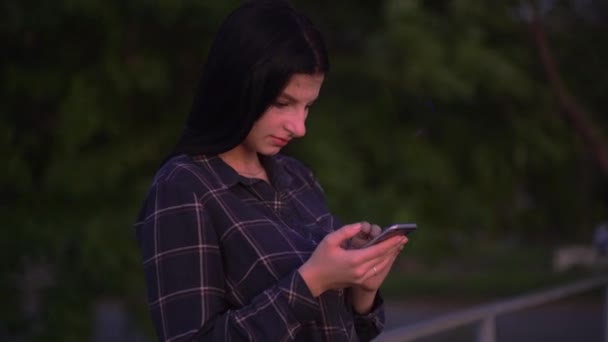 Mujer atractiva con teléfono inteligente en la calle, caminando y mensajes de texto en el teléfono — Vídeos de Stock