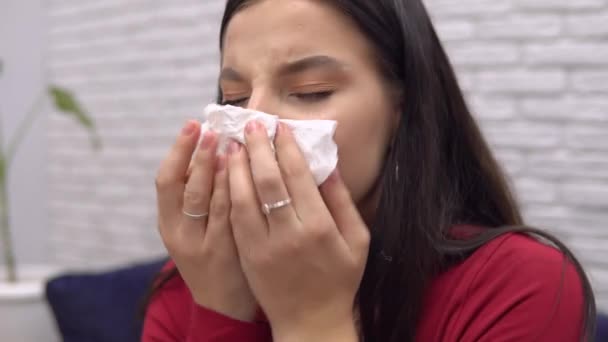 Хвороба жінка чхає і капає ніс, хвора вдома, використовує спрей, вловлює вірус — стокове відео