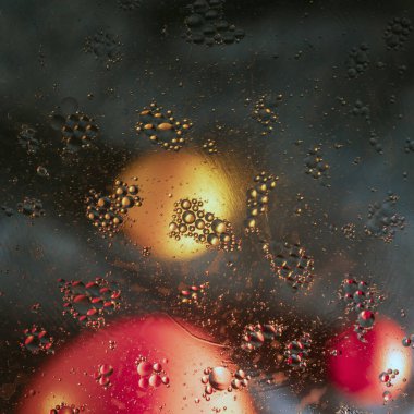 Bulanık arka planda meyveli sihirli yağ damlaları.