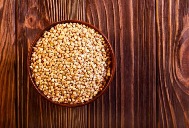 Bir ahşap kase çiğ yeşil buğday