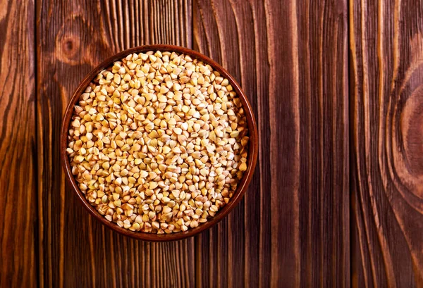 Bir ahşap kase çiğ yeşil buğday