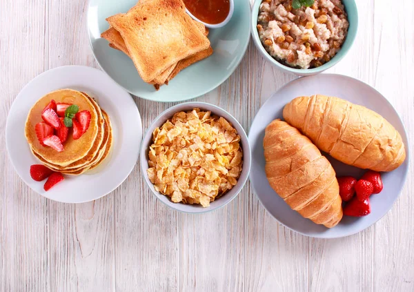 Sweet Frukostar Bord Pannkakor Rostat Bröd Gröt Croissanter Och Cornflakes — Stockfoto