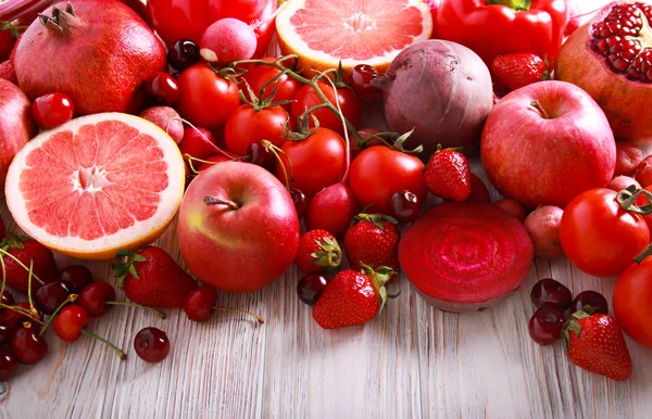 赤い色野菜と木製のテーブルの上の果物の盛り合わせ — ストック写真