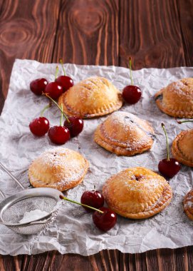 Ahşap masa üzerinde kagit üzerinde kiraz mini turta