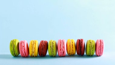 Farklı renkli kek - macaroons üzerinde arka plan mavi.