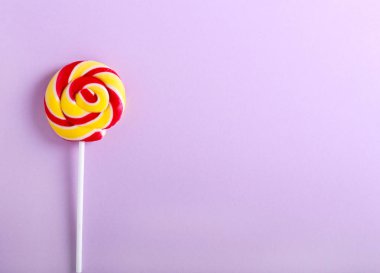 Mor Kağıt arka plan üzerinde renkli girdap lolipopları çok