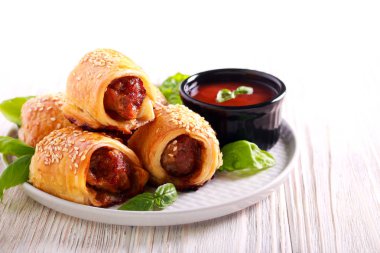 Üst plaka üzerinde susam ile mini sosis rolls