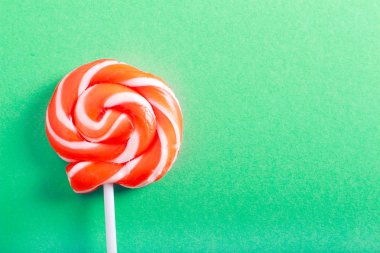 Turuncu ve beyaz yeşil arka plan üzerinde lolipop girdap