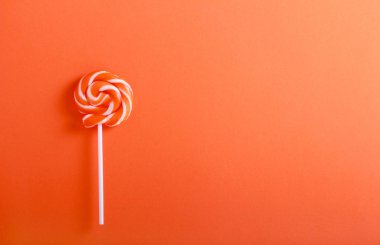 Turuncu ve beyaz turuncu arka plan üzerinde lolipop girdap