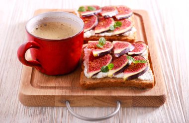 İncir ve ricotta sandviç ve kahve ahşap tahta üzerinde açın