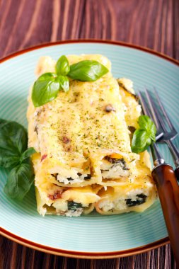 Ricotta peyniri ve plaka üzerinde makarna doldurduktan ıspanak