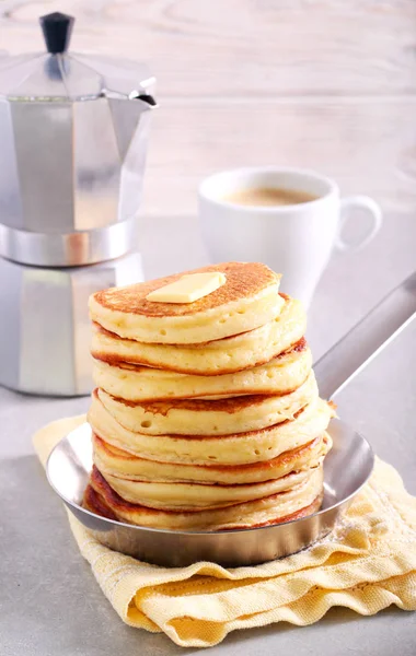 Pile of pancakes in a pan with butter