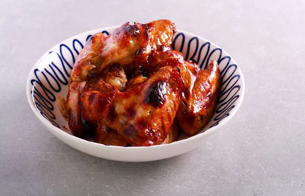 Grilled sticky chicken wings in a bowl