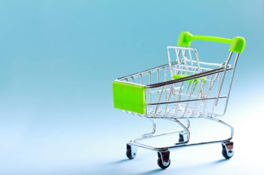 Mavi arka plan üzerinde boş mini alışveriş sepeti