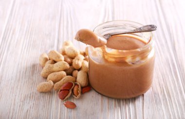 Ahşap masa üzerinde bir kavanoz fıstık yağı
