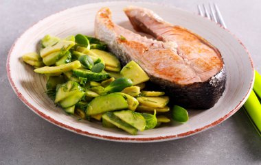 Kızarmış balık biftek ve salata plaka üzerinde