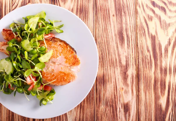 Salmon and salad on plate - healthy dinner