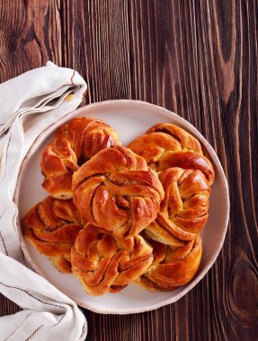 Ahşap arka plan üzerinde plaka üzerinde tarçınlı çörek