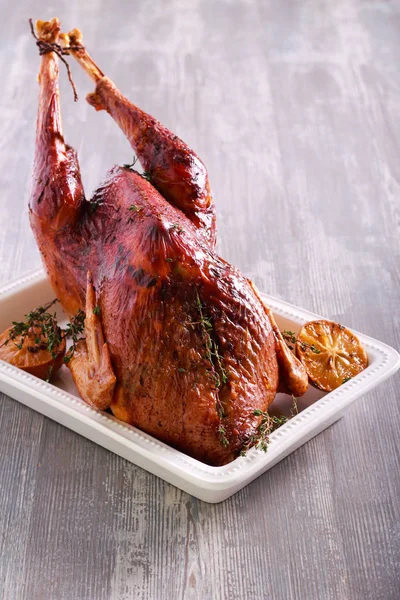 Roast turkey with thyme and lemon in a tin