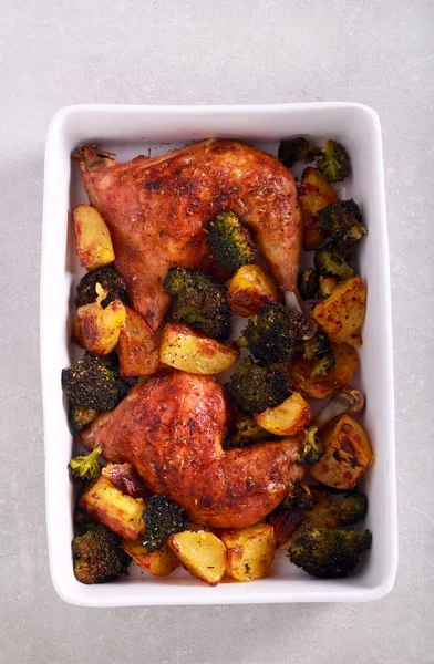 Roast chicken legs with broccoli and potato in a tin