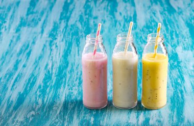 Mavi arka plan üzerinde şişelerde farklı güler yüzlü yelpazesi