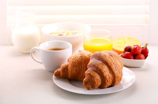Desayuno con cruasán, zumo de naranja y café servido —  Fotos de Stock