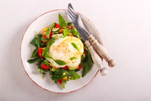 Salad with fried egg on top — Stock Photo, Image