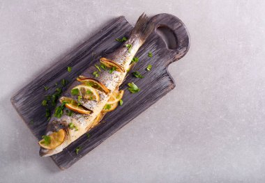 Ahşap tahtada pişirilmiş limon deniz kabuğu balığı.