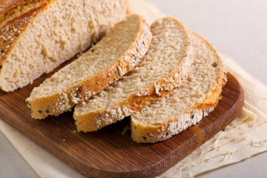 Tahtada dilimlenmiş ev yapımı buğday tohumu ekmeği.