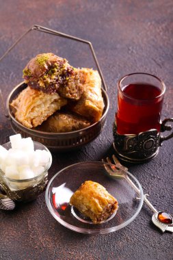 Baklava tatlı tatlısı. Koyu masa üzerinde çay ile servis edilir.