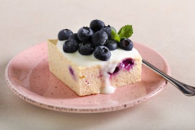 Tabakta servis edilen yaban mersinli cheesecake dilimi