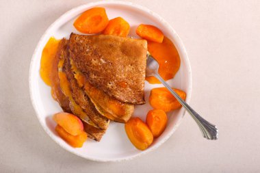 Kayısı reçelli krepler, tabakta servis edilir.