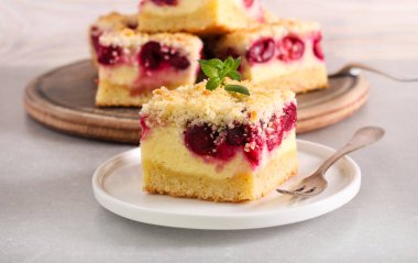 Vişneli ve hindistancevizli cheesecake, tabakta servis ediliyor.