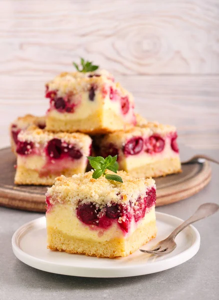 Vişneli ve hindistancevizli cheesecake, tabakta servis ediliyor.