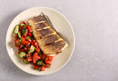 Sağlıklı yemek, salata ve kızarmış beyaz balık, levrek.