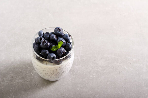 Chia seed pudding with blueberry topping, served in glass