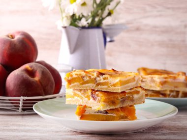 Şeftalili kremalı pasta dilimleri tabakta.