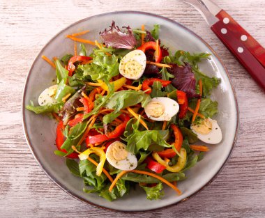 Taze sebze ve bıldırcın yumurtası tabakta.