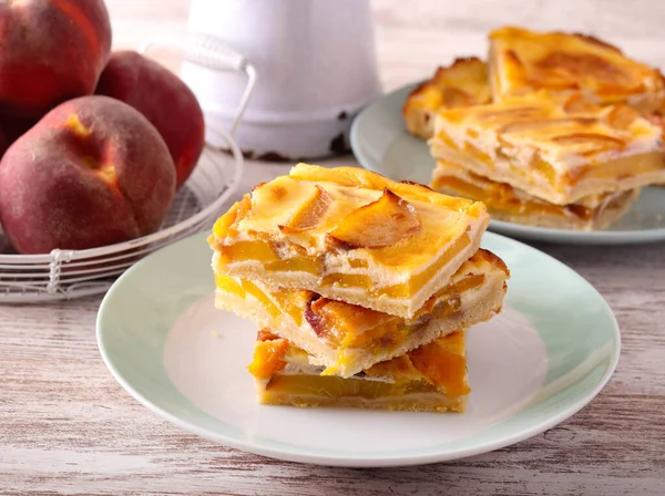 Şeftalili kremalı pasta dilimleri tabakta.