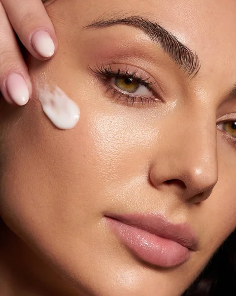 Primer plano retrato de belleza riendo hermosa mujer medio desnuda aplicación de crema facial maquillaje salud spa piel fresca — Foto de Stock