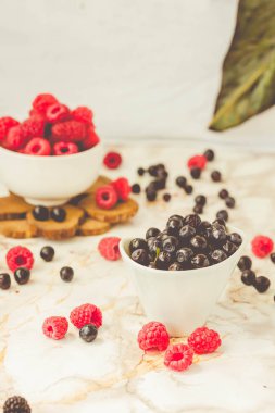 Taze çiğ ahududu ve beyaz bardak yaban mersini. Yaz meyve, çilek. Detoks diyetler ve sağlıklı gıda kavramı. Tonlama.