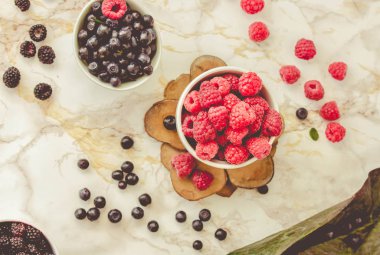 Ham ahududu ve beyaz bardak yaban mersini. beyaz mermer zemin. Yaz meyve, çilek. Detoks diyetler ve antioksidan gıda kavramı. Toning.Top görünüm.