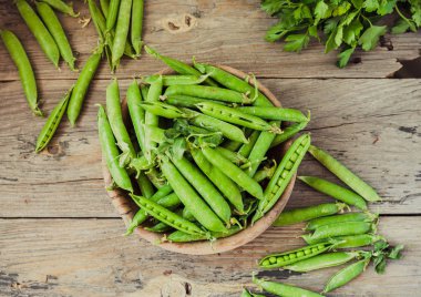 Yeşil bezelye POD üzerinde gri bir ahşap masa. Vegetables.Detox diyet ve yeşil yaz yiyecek konsepti.